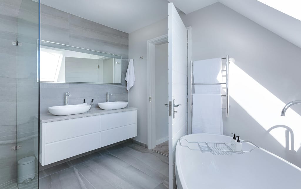 curtis design build inc. Sleek contemporary bathroom with bathtub and twin sinks, showcasing minimalist design and luxury.